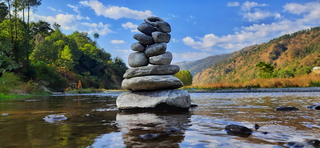 Stacked stones by river in mountain landscape