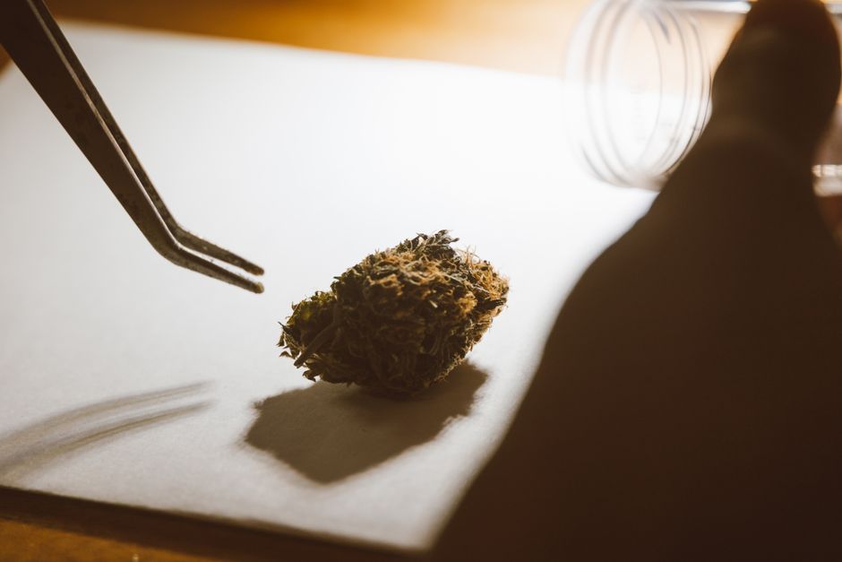 Tongs and cannabis bud on white paper