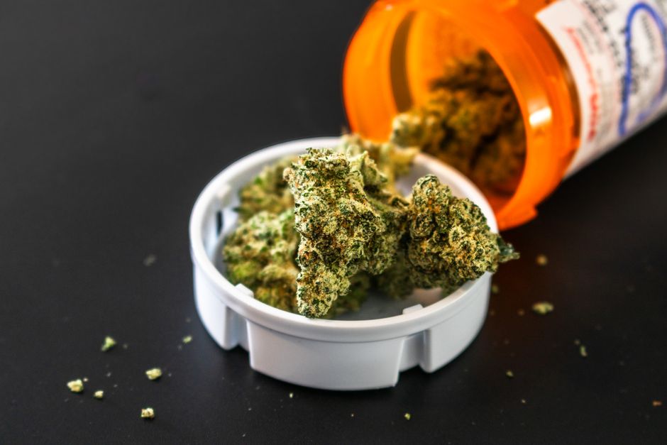 Cannabis buds spilled from prescription bottle