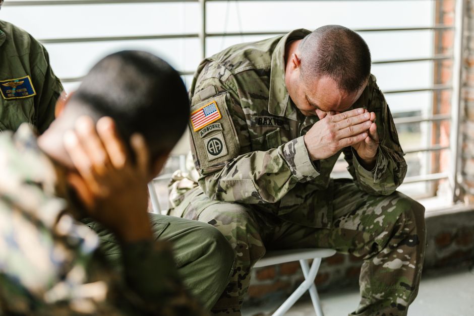 Stressed military soldiers sitting and coping