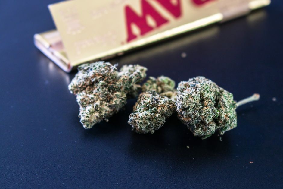 Three cannabis buds near RAW rolling papers