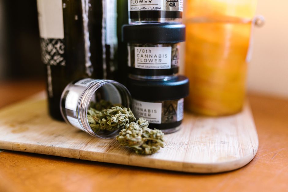 Jars of cannabis flower on wooden board