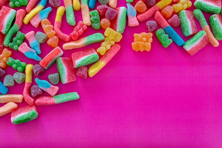 Various gummy candies on bright pink background